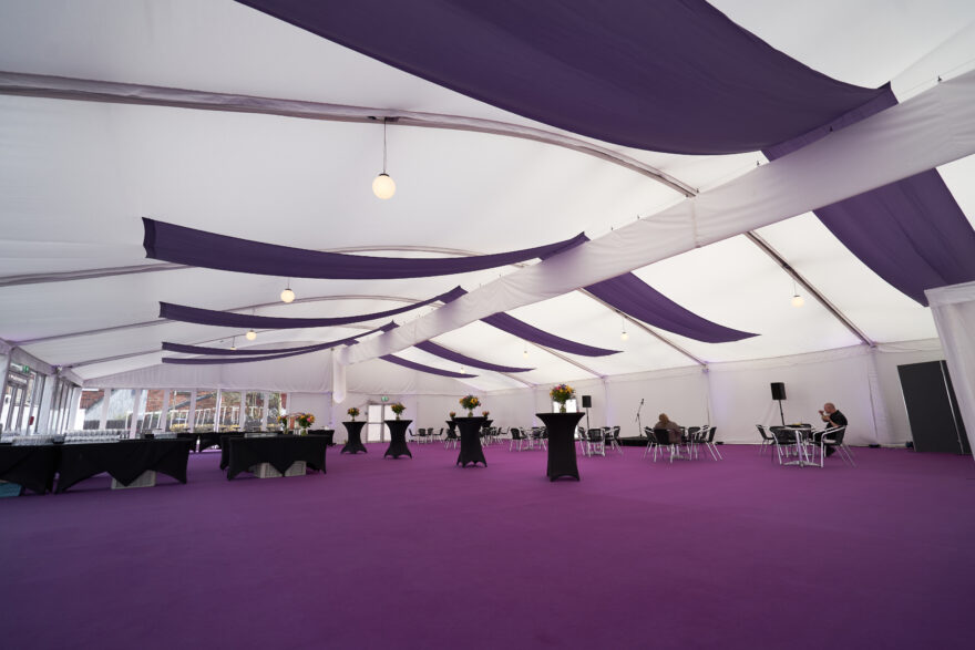 Purple bespoke branded lining inside GL events UK temporary graduation structure for University of Manchester